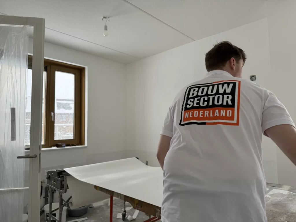 Behangwerk in uitvoering door een vakman van Bouwsector Nederland